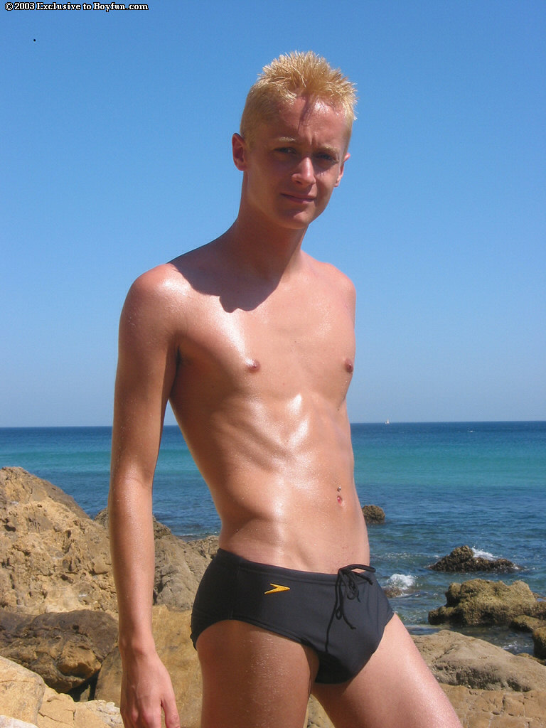 Skinny gay blonde Kyle strips his Speedos and masturbates on the beach